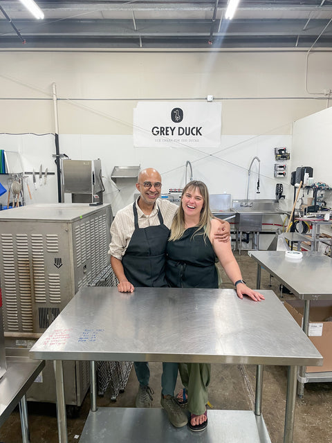 a man and a woman standing in an ice cream production facility